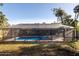 Backyard view of screened-in pool surrounded by well-manicured lawn and mature trees at 464 Nash Ln, Port Orange, FL 32127