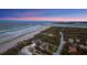 Breathtaking aerial view of beachside property, showcasing coastline, nearby community and well manicured landscape at 4911 S Atlantic Ave, Ponce Inlet, FL 32127