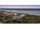Aerial view of a beautiful beachfront home with lush landscaping, offering stunning ocean views and a private retreat at 4911 S Atlantic Ave, Ponce Inlet, FL 32127