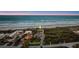 Aerial view showing the beach front location of this home, with ocean views, and lush landscaping at 4911 S Atlantic Ave, Ponce Inlet, FL 32127