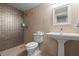 Modern bathroom featuring a walk-in shower with textured tile, pedestal sink, and sleek fixtures at 4911 S Atlantic Ave, Ponce Inlet, FL 32127