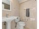 Bright bathroom featuring a pedestal sink, toilet, and neutral-toned tile at 4911 S Atlantic Ave, Ponce Inlet, FL 32127