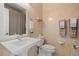 Neutral toned bathroom featuring a toilet, sink and neutral patterned wallpaper at 4911 S Atlantic Ave, Ponce Inlet, FL 32127