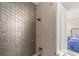 Bathroom shower featuring rainfall shower head, glass shelf, and tiled walls at 4911 S Atlantic Ave, Ponce Inlet, FL 32127