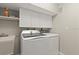 Functional laundry room equipped with modern washer, dryer, sink, and white cabinets at 4911 S Atlantic Ave, Ponce Inlet, FL 32127