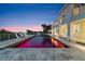 The pool area of a luxurious home with lounge chairs, overlooking the ocean at dusk at 4911 S Atlantic Ave, Ponce Inlet, FL 32127