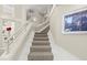 Elegant staircase featuring carpeted steps, white railings and walls, and decorative artwork at 4911 S Atlantic Ave, Ponce Inlet, FL 32127