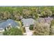 Aerial view of a home with a well-manicured lawn, mature trees, and a screened in pool area at 509 Victoria Hills Dr, Deland, FL 32724