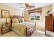 Bedroom with a ceiling fan, large window with outdoor views, and tropical decor at 509 Victoria Hills Dr, Deland, FL 32724