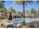 Community pool surrounded by palm trees, lounge chairs, and seating areas at 509 Victoria Hills Dr, Deland, FL 32724