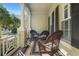 Charming front porch with rocking chairs, striped rug, and decorative plants, perfect for relaxation at 509 Victoria Hills Dr, Deland, FL 32724