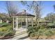 A gazebo with a hexagonal roof is in a garden with lush greenery and trees at 509 Victoria Hills Dr, Deland, FL 32724