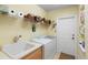 Laundry room features appliances, a sink, and shelving for storage and organization, as well as an exterior door at 509 Victoria Hills Dr, Deland, FL 32724