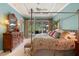 Light-filled bedroom with a four-poster bed, a view of outdoor living, and a cozy bench at 509 Victoria Hills Dr, Deland, FL 32724