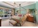 Spacious main bedroom with a canopy bed, tray ceiling, and peaceful backyard view at 509 Victoria Hills Dr, Deland, FL 32724
