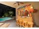 Outdoor bar with tropical decor, a thatched roof, and a view of the pool create a vacation-inspired retreat at 509 Victoria Hills Dr, Deland, FL 32724