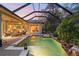 Enclosed pool area boasts tropical landscaping, a spa, a covered patio and outdoor living spaces for entertainment at 509 Victoria Hills Dr, Deland, FL 32724