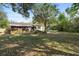 Large, lush backyard with mature trees, screened lanai, and hammock, ideal for outdoor enjoyment at 514 Land O Lakes Ct, Deland, FL 32724