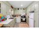 Charming kitchen featuring tile floors, white appliances, and ample cabinet storage at 514 Land O Lakes Ct, Deland, FL 32724