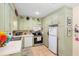 Charming kitchen featuring tile floors, white appliances, and ample cabinet storage at 514 Land O Lakes Ct, Deland, FL 32724