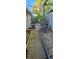 Narrow side yard featuring an air conditioner unit, planted garden area and concrete walkway at 520 Dixson St, Orange City, FL 32763