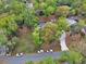 Aerial view of a lush landscape with a private pool, mature trees, and a winding driveway at 525 E Wisconsin Ave, Orange City, FL 32763