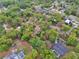 An aerial view of a wooded neighborhood with homes featuring pools and well established landscaping at 525 E Wisconsin Ave, Orange City, FL 32763