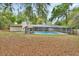 A spacious backyard featuring a gazebo and screened-in pool area with mature trees providing ample shade at 525 E Wisconsin Ave, Orange City, FL 32763