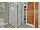 Modern bathroom featuring a glass-enclosed shower with white subway tile and rustic wood storage at 525 E Wisconsin Ave, Orange City, FL 32763