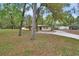 Well-maintained single-story home with mature trees and a circular driveway enhancing its natural setting and curb appeal at 525 E Wisconsin Ave, Orange City, FL 32763