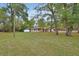 Quaint single story house surrounded by mature trees and an expansive, well-maintained front lawn at 525 E Wisconsin Ave, Orange City, FL 32763
