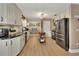 Modern kitchen with white cabinets, stainless steel appliances, and a view into the dining area at 525 E Wisconsin Ave, Orange City, FL 32763
