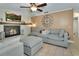 Comfortable living room with fireplace and large sectional sofa under ceiling fan at 525 E Wisconsin Ave, Orange City, FL 32763