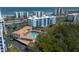 Aerial view showcasing condo complex with pool, lush landscaping, and proximity to the beach at 5300 S Atlantic Ave # 17-303, New Smyrna Beach, FL 32169