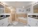 Well-lit bathroom featuring a tub, glass enclosed shower, and double sink vanity at 5300 S Atlantic Ave # 17-303, New Smyrna Beach, FL 32169