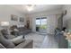 Open living room with doors to patio with view of lush landscaping at 5300 S Atlantic Ave # 17-303, New Smyrna Beach, FL 32169