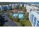 Aerial shot of tennis courts, a pool, and condos in a tropical community at 5300 S Atlantic Ave # 17-303, New Smyrna Beach, FL 32169