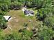 Aerial view of a well-maintained home with a fenced backyard, spacious lawn, and a storage building at 53731 Rivertrace Rd, Astor, FL 32102