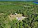 Drone shot capturing a rural home with a large outbuilding, surrounded by green forest land at 53731 Rivertrace Rd, Astor, FL 32102