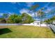 Grassy backyard enclosed with a white fence with trees surrounding the area at 538 Gertrude Ln, South Daytona, FL 32119