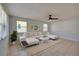 Sunlit living room showcasing neutral tones, tiled floors, a ceiling fan, and large windows for abundant natural light at 538 Gertrude Ln, South Daytona, FL 32119