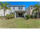 A view of the home's backyard with a covered patio, green grass, and lush landscaping at 544 Red Rose Ln, Sanford, FL 32771
