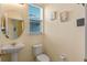 Cozy powder room with pedestal sink, stylish fixtures, and natural light from window at 544 Red Rose Ln, Sanford, FL 32771