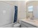 Bright bathroom featuring a shower-tub combo with white tile and a vanity with solid surface counters at 544 Red Rose Ln, Sanford, FL 32771