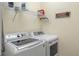 Convenient laundry room featuring modern washer and dryer with overhead shelving at 544 Red Rose Ln, Sanford, FL 32771