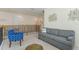 Bright loft area with a comfortable gray sofa, blue arm chair and modern art wall decor above the staircase at 544 Red Rose Ln, Sanford, FL 32771