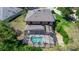 Aerial view of the home featuring a screened-in pool, patio, and lush greenery at 553 Quail Lake Dr, Debary, FL 32713