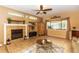 Inviting living room with a fireplace, ceiling fan, and a large window for natural light at 553 Quail Lake Dr, Debary, FL 32713