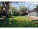 Large backyard featuring mature trees and a covered patio off the back of the home at 597 Gainsboro St, Deltona, FL 32725