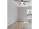 A bright, airy bedroom with light wood floors, ceiling fan, and a large window at 597 Gainsboro St, Deltona, FL 32725